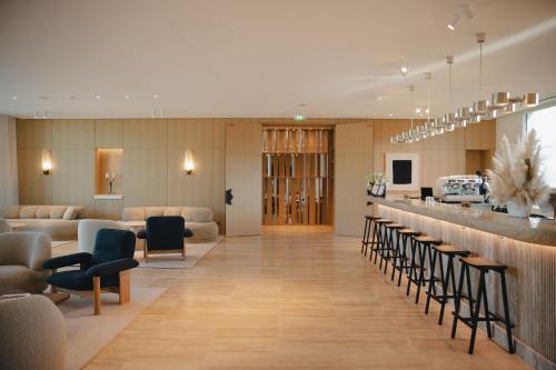 a hotel lobby with a bar with chairs and tables at Domaine de Verchant & Spa - Relais & Châteaux in Montpellier
