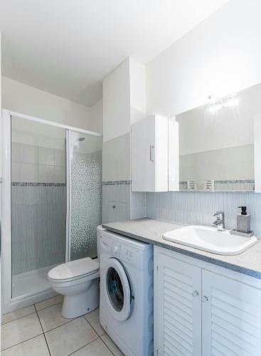 une salle de bain avec une machine à laver et un lavabo dans l'établissement Studio Marco Polo Mandelieu - proche mer, à Mandelieu-la-Napoule
