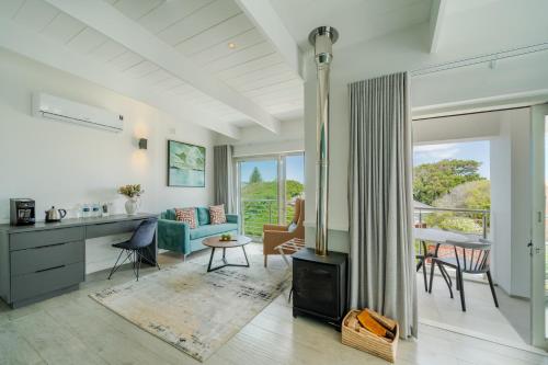 a kitchen and living room with a fireplace and a table at One Marine Drive Boutique Hotel & Spa by The Living Journey Collection in Hermanus
