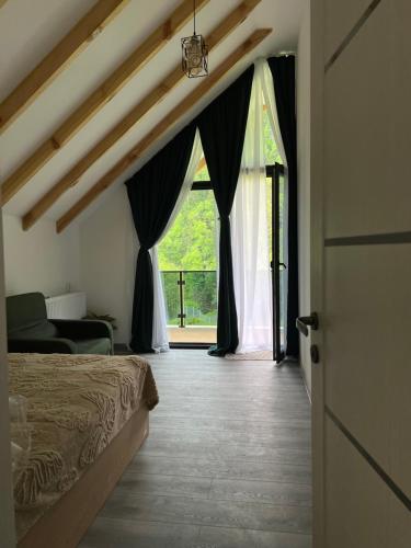 a bedroom with a bed and a large window at MTA house - Borjomi in Borjomi