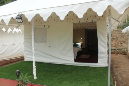 a white tent with a bed in it at Billing View Camp and Mud Houses,Bir in Aiju