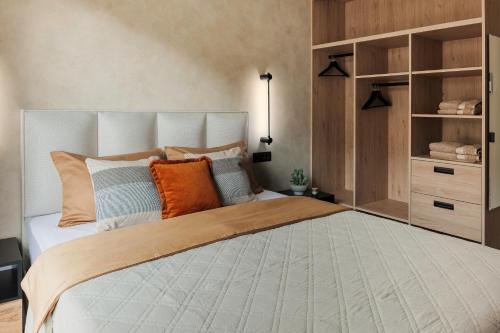 a bedroom with a large bed with orange and blue pillows at U-NIGHT Hostel Budva in Budva