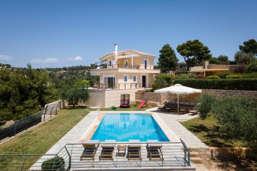 a house with a swimming pool in front of it at Hegemoni Villa Porto Heli in Porto Heli