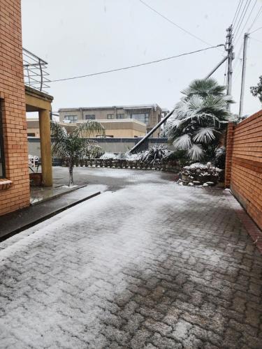 a driveway covered in snow next to a brick building at NobelAqua Suites in Maseru