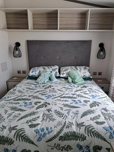 a bed with a blanket and pillows on it at Tranquil Lodge Retreat in Paignton in Paignton