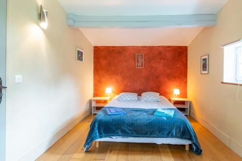 a bedroom with a bed with a blue comforter at Chalet En Bois in Saint-Cernin-de-lʼHerm