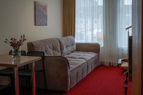 a living room with a couch and a table at Agneta Apartamentai in Druskininkai