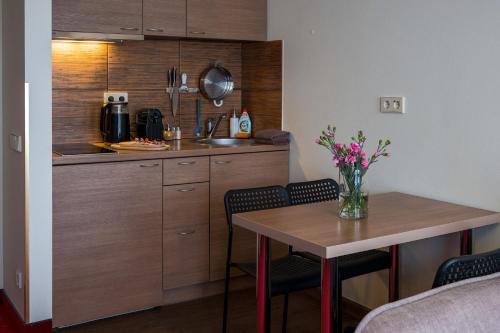 a kitchen with a table and a counter with chairs at Agneta Apartamentai in Druskininkai