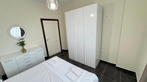 a bedroom with a white bed and a mirror at Solemar Apartments Lalzi Bay in Lalzit Bay
