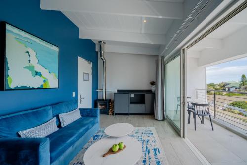 a living room with a blue couch and a table at One Marine Drive Boutique Hotel & Spa by The Living Journey Collection in Hermanus