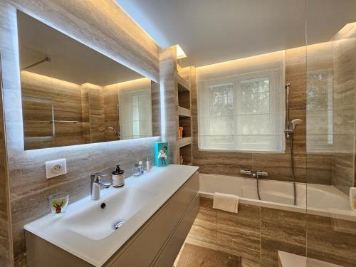 une salle de bain avec un lavabo, une baignoire et un miroir dans l'établissement 3 bedroom house in the center of Cannes, à Cannes