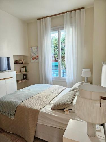 une chambre avec un grand lit et une fenêtre dans l'établissement 3 bedroom house in the center of Cannes, à Cannes