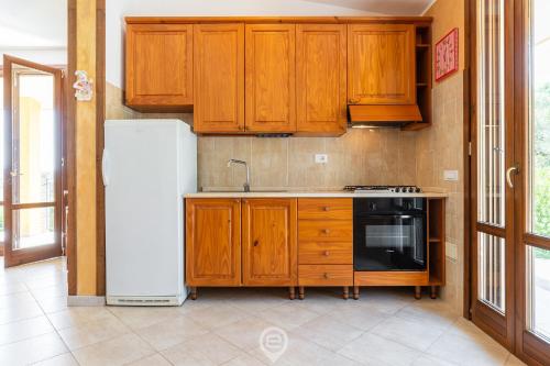 a kitchen with wooden cabinets and a white refrigerator at Wide Horizons House in Simius