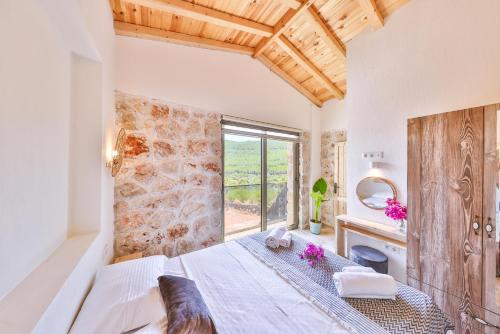 a bedroom with a bed and a large window at Nouba Villas in Kaş