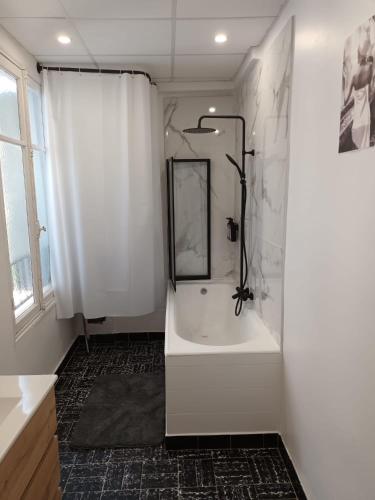 une salle de bain blanche avec une baignoire et une douche dans l'établissement Appartement 2 chambres à Cannes, à Cannes