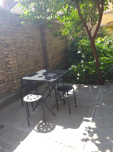 a black table and two chairs sitting on a patio at Deák Szobák in Nagykőrös