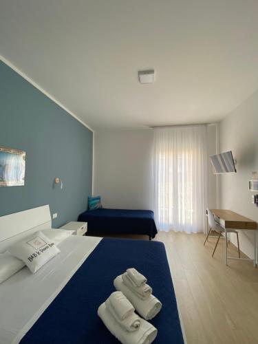 a hotel room with a bed with towels on it at B&B Le Venere Rooms in Castellammare del Golfo