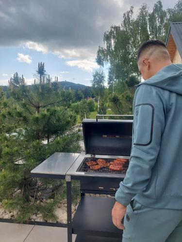 a man is cooking food on a grill at GOLaskowa in Laskowa