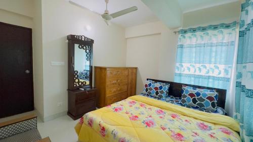 a bedroom with a bed and a dresser and a mirror at Baridhara Sweet Home in Dhaka