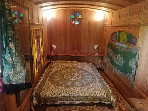 une petite chambre avec un lit dans un wagon dans l'établissement Les Arts En Ciel, à Neuvy-Grandchamp