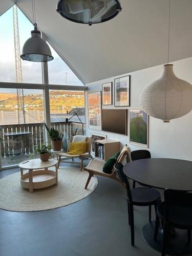 a living room with couches and a table and chairs at Charming Apartment in Strendur Faroe Islands, with Stunning Seaview in Strendur