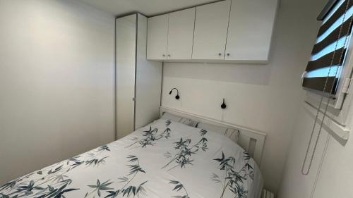 Cette petite chambre comprend un lit et une armoire blanche. dans l'établissement Appartement Neuf - Six Fours Les plages - Parking privatif - Clim - Balcon - 500m de la mer, à Six-Fours-les-Plages