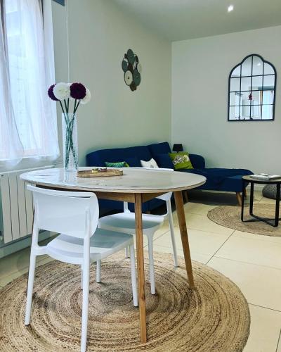 une table blanche et des chaises dans un salon dans l'établissement La calèche, la Diligence, centre St Jean de Losne, à Saint-Jean-de-Losne