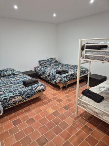 Cette chambre dispose de 3 lits superposés et d'un sol en briques. dans l'établissement Gite de l usine CAVE AUMONT, à Roussay