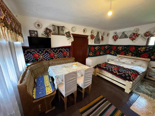 een kamer met 2 bedden en een tafel en een bank bij Glamping - Casuta de pe Fiad in Romuli