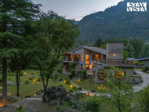 an image of a house with a mountain at StayVista at Moets Waterfront Estate by the Riverside - 3BR with BBQ, Bonfire and Lawn in Manāli