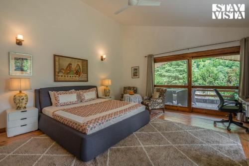 a bedroom with a bed and a large window at StayVista at Moets Waterfront Estate by the Riverside - 3BR with BBQ, Bonfire and Lawn in Manāli