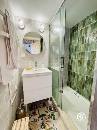 une salle de bain avec une douche, un lavabo et un miroir dans l'établissement Au bon accueil, à Badens