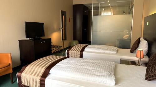 Postel nebo postele na pokoji v ubytování Hotel Lumière an der Messe