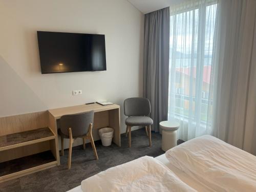 a hotel room with a bed and a desk and a television at Hotel Natur Akureyri in Akureyri
