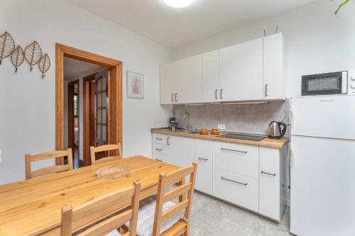 a kitchen with a wooden table and a white refrigerator at Casa Rosi in Frontera