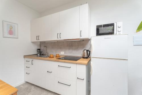 a kitchen with white cabinets and a white refrigerator at Casa Rosi in Frontera
