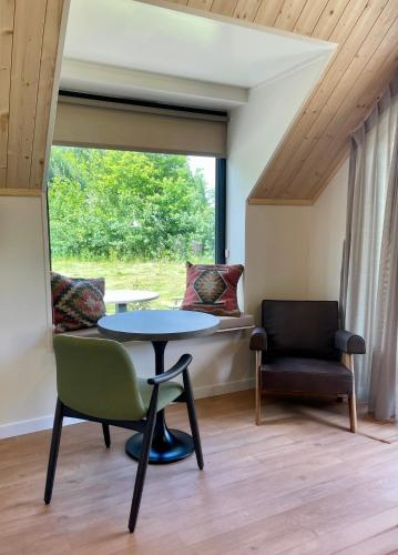 a room with a table and a chair and a window at Recreatiepark De Bosrand in Oudemirdum