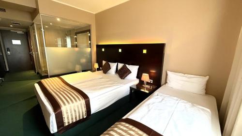 Postel nebo postele na pokoji v ubytování Hotel Lumière an der Messe