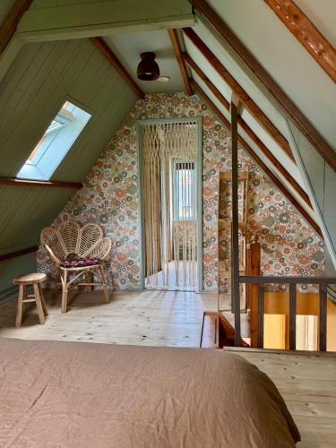 a attic room with a bed and a window at In de Aap - Appartementen & Guesthouse in Bergen