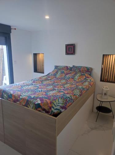 une chambre avec un lit avec une couette colorée dans l'établissement Appartement moderne proche Paris, aéroport et disneyland, à Le Perreux-Sur-Marne