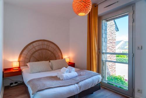 a bedroom with a bed and a large window at Le Mayalou - Vue Mer in Sarzeau