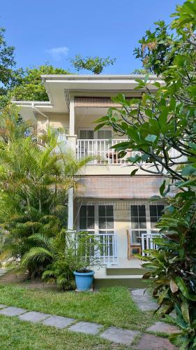 a house with a porch and a chair in the yard at Bord Mer Villa in Beau Vallon