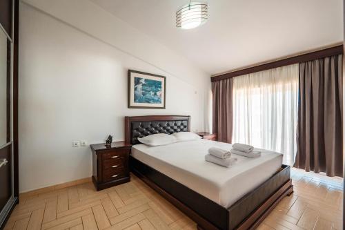 a bedroom with a large bed and a window at ALNES HOTEL in Sarandë