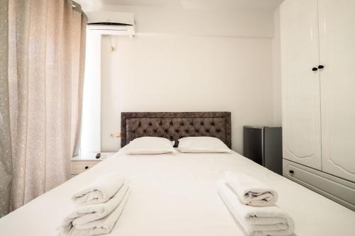 a bedroom with a white bed with towels on it at ALNES HOTEL in Sarandë