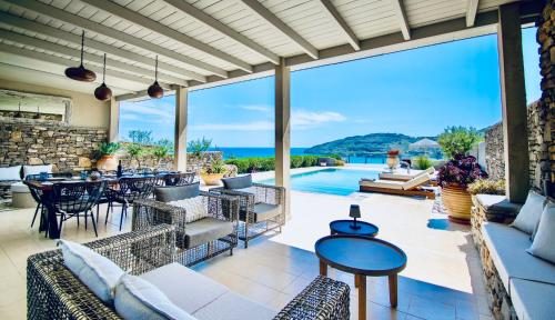 an outdoor patio with tables and chairs and a pool at VLK: Villa Lindos Kalliopi, Rhodes in Líndos