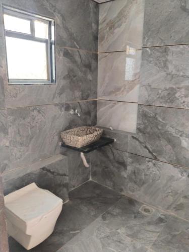 a bathroom with a toilet and a window at Kalyan luxury rooms in Garudeshwar