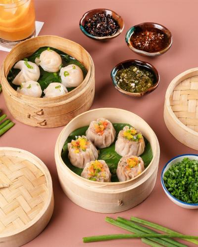 a table topped with wooden bowls filled with dumplings at Radisson Blu Hotel New Delhi Dwarka in New Delhi