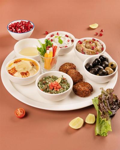 a plate of food with bowls of different foods at Radisson Blu Hotel New Delhi Dwarka in New Delhi