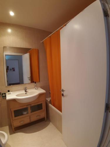 a bathroom with a sink and a mirror at Casa do lago em Sol Tróia in Troia