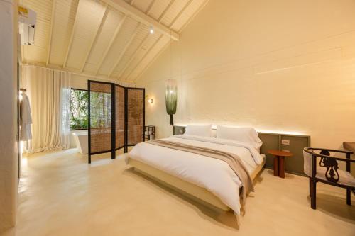a bedroom with a large bed and a bath tub at Arde La Selva in Santa Fe de Antioquia